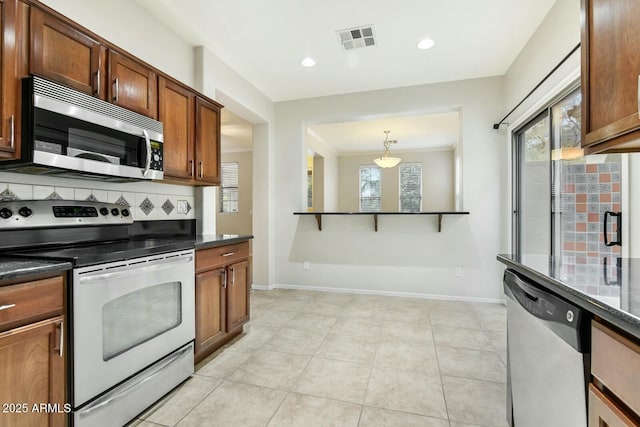 kitchen with light tile patterned floors, tasteful backsplash, visible vents, appliances with stainless steel finishes, and baseboards