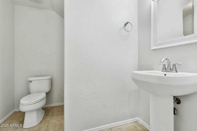 bathroom with a sink, tile patterned flooring, toilet, and baseboards