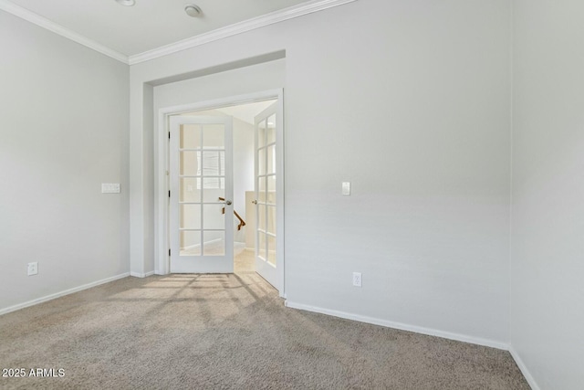 carpeted empty room featuring baseboards and crown molding