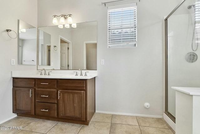 bathroom with a shower stall, double vanity, a sink, and tile patterned floors