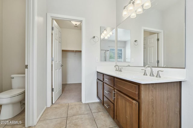 full bathroom featuring double vanity, a sink, toilet, and tile patterned floors