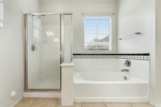 bathroom featuring a stall shower, tile patterned flooring, and a garden tub