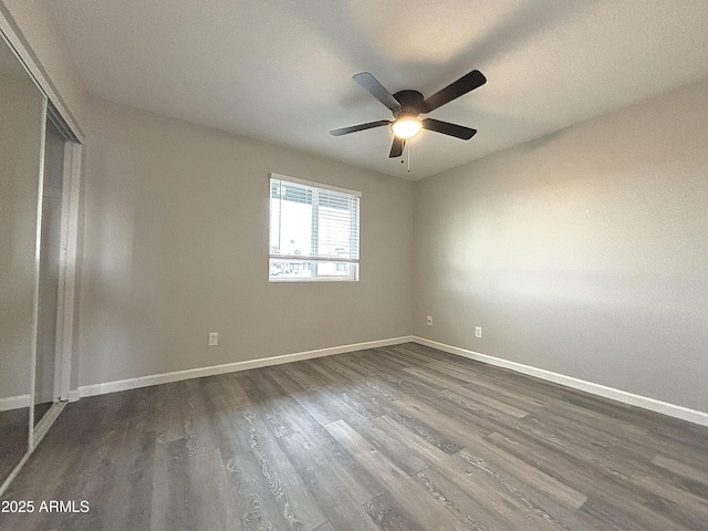 spare room featuring dark wood-type flooring and ceiling fan