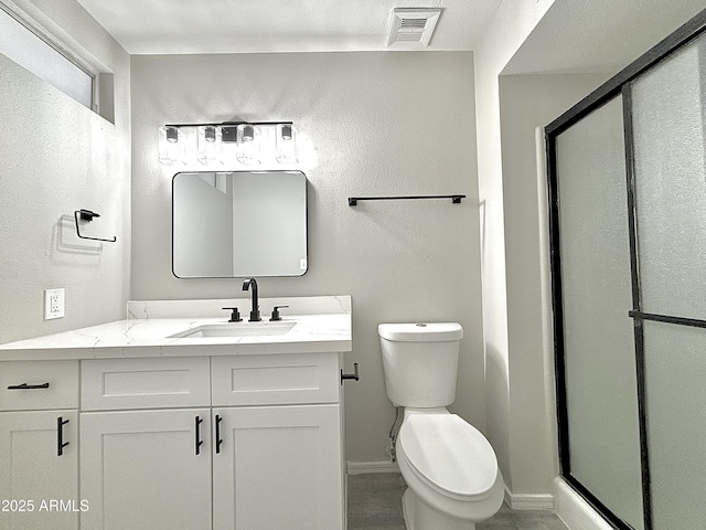 bathroom featuring vanity, toilet, and walk in shower