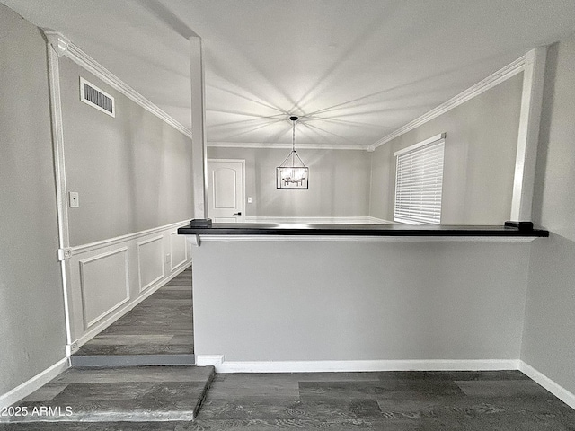 kitchen with ornamental molding, dark hardwood / wood-style flooring, and decorative light fixtures