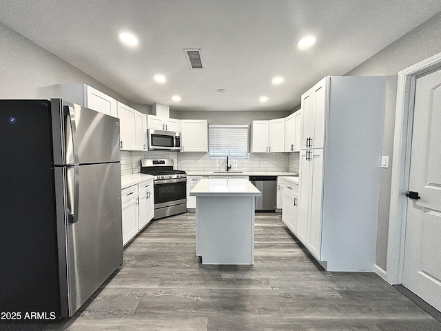 kitchen featuring white cabinetry, sink, stainless steel appliances, and a center island