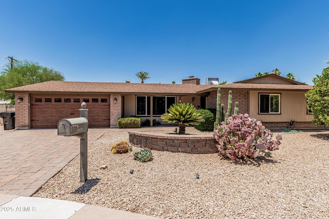 8620 E Sells Dr, Scottsdale, AZ 85251 - ranch-style home with an attached garage, brick siding, a chimney, driveway, and a shingled roof