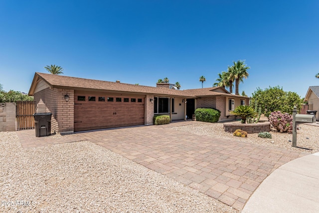 8620 E Sells Dr, Scottsdale, AZ 85251 - ranch-style home featuring an attached garage, brick siding, decorative driveway, and a chimney
