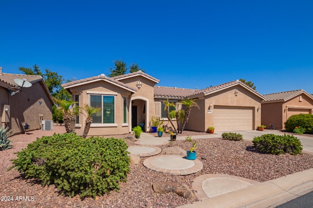 mediterranean / spanish-style home featuring central air condition unit and a garage