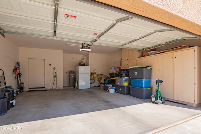 garage with a garage door opener and white refrigerator