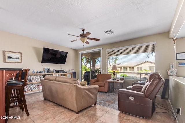 tiled living room featuring a textured ceiling and ceiling fan