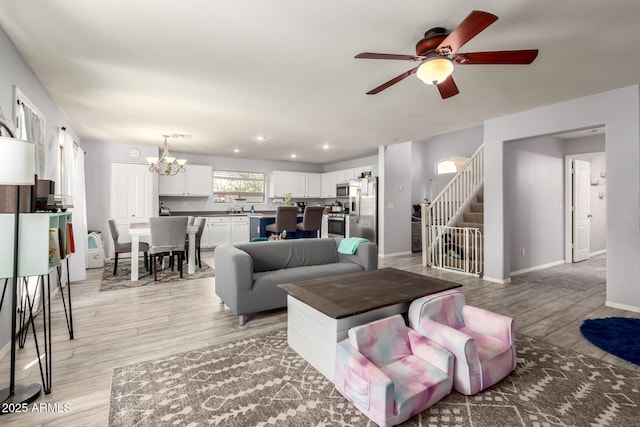 4034 E Mine Shaft Rd, San Tan Valley, AZ 85143 - living area with a ceiling fan, light wood-style floors, a chandelier, stairs, and baseboards