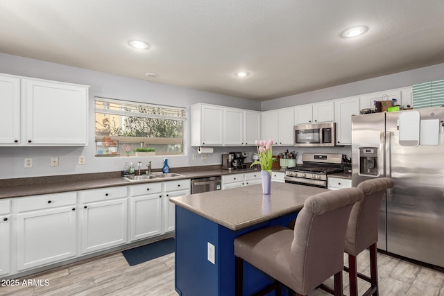 4034 E Mine Shaft Rd, San Tan Valley, AZ 85143 - kitchen with appliances with stainless steel finishes, a sink, dark countertops, a breakfast bar, and white cabinets