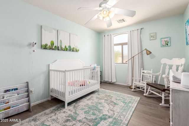 4034 E Mine Shaft Rd, San Tan Valley, AZ 85143 - bedroom with wood finished floors, a crib, baseboards, and ceiling fan
