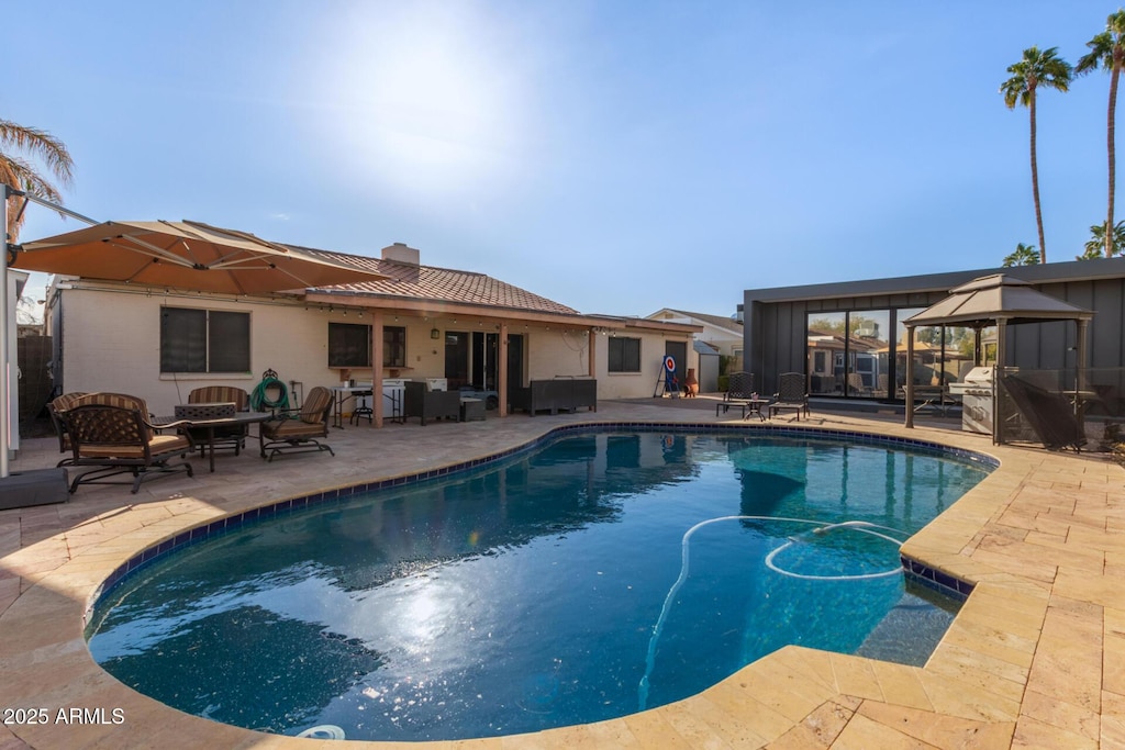 view of pool with a gazebo, a sunroom, a patio, and an outdoor hangout area