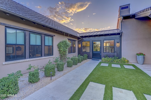 exterior entry at dusk with a yard