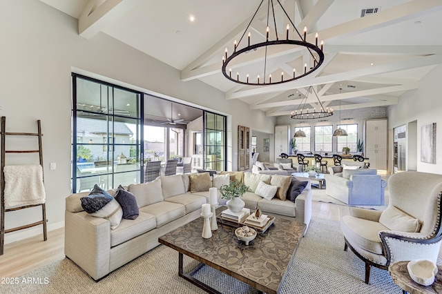 living room featuring a chandelier, lofted ceiling with beams, and light hardwood / wood-style flooring