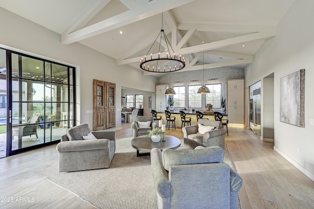 living room featuring beamed ceiling, light wood-type flooring, high vaulted ceiling, and a chandelier