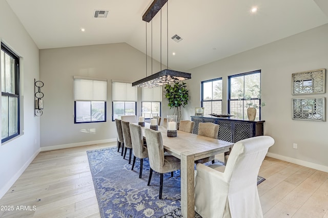 dining room with light hardwood / wood-style floors and vaulted ceiling