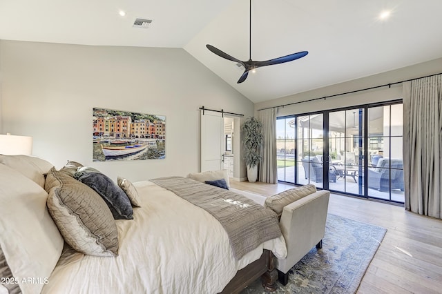 bedroom featuring high vaulted ceiling, ceiling fan, a barn door, access to exterior, and light wood-type flooring