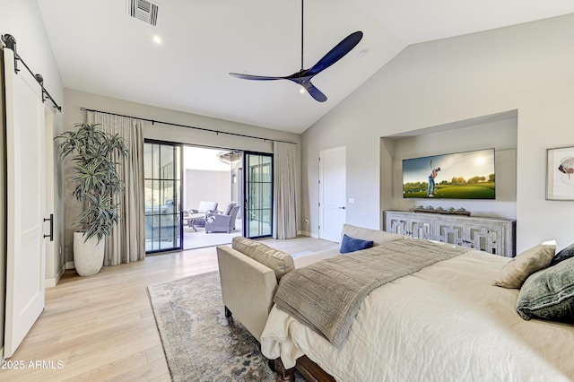 bedroom featuring access to exterior, light wood-type flooring, ceiling fan, a barn door, and high vaulted ceiling