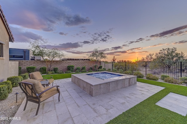 pool at dusk with an in ground hot tub, a yard, and a patio