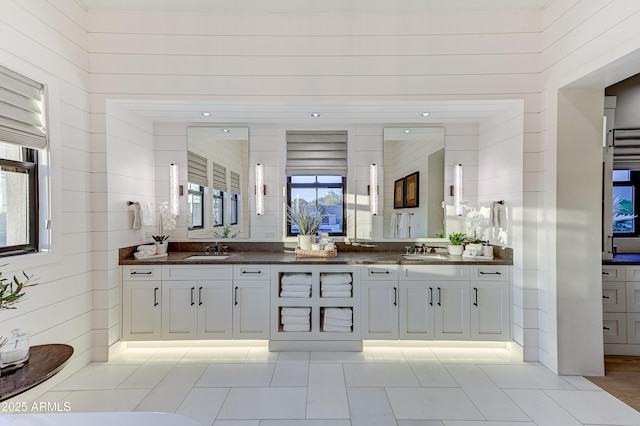 bathroom with vanity, tile patterned floors, and wood walls