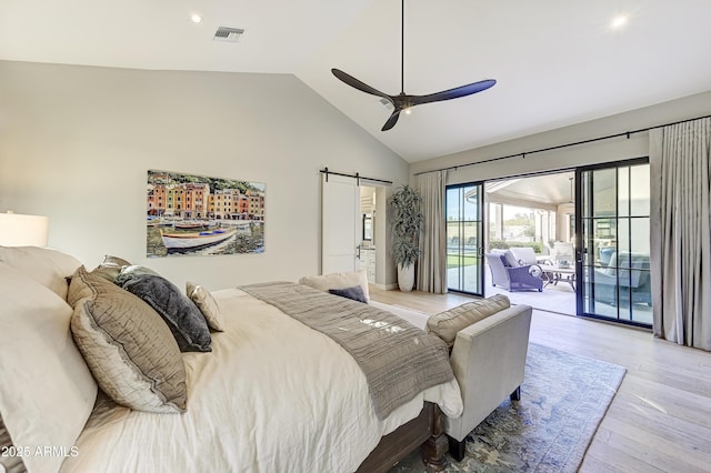 bedroom featuring ceiling fan, a barn door, high vaulted ceiling, access to outside, and light wood-type flooring