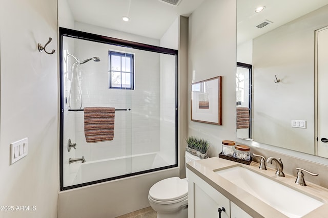 full bathroom with combined bath / shower with glass door, vanity, and toilet