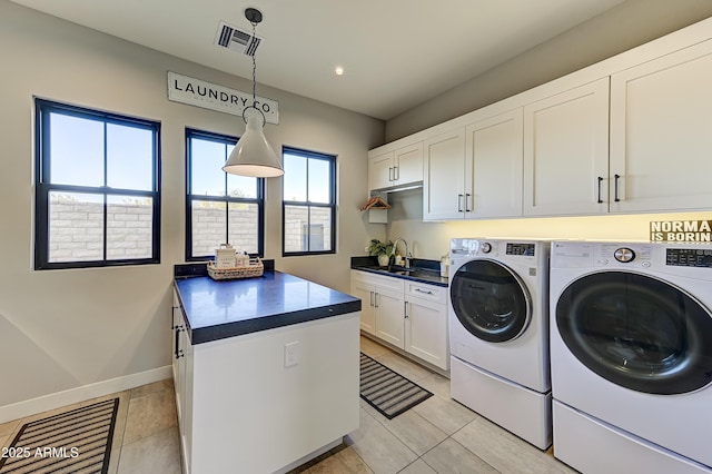 laundry room featuring washer and clothes dryer, cabinets, light tile patterned floors, and sink