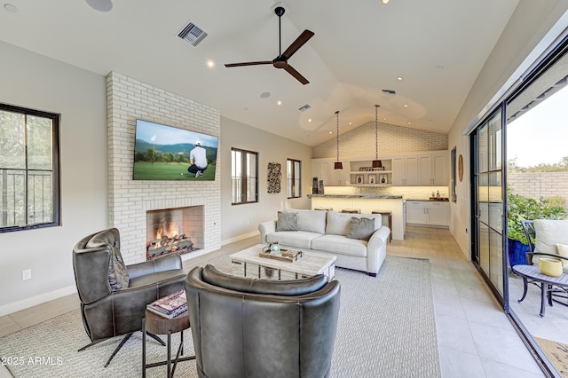 living room with a fireplace, ceiling fan, lofted ceiling, and light tile patterned flooring