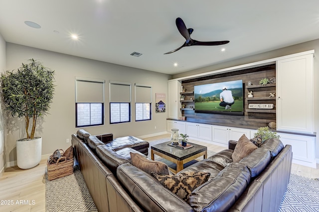 cinema room featuring ceiling fan and light wood-type flooring