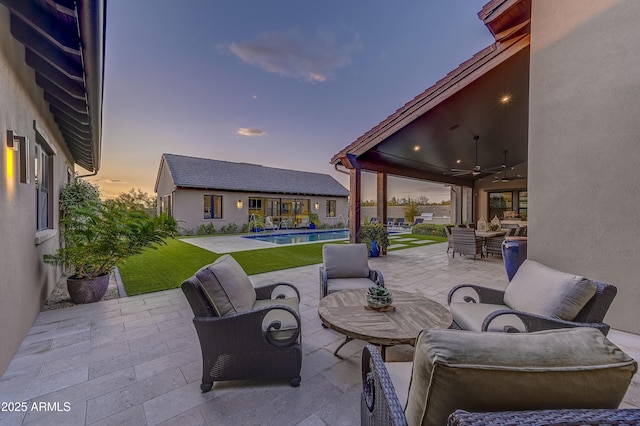 patio terrace at dusk with an outdoor hangout area and ceiling fan