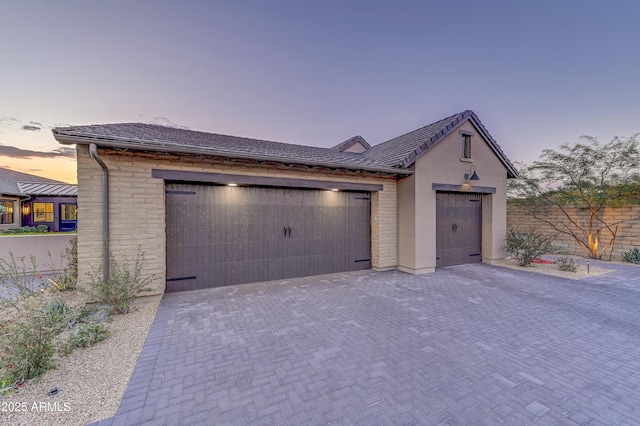 view of garage at dusk