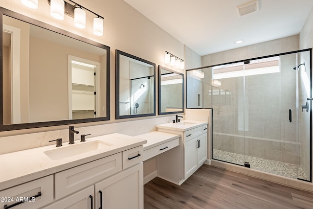 bathroom with a shower with door, vanity, and wood-type flooring