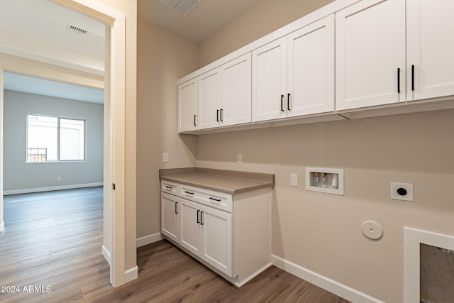 washroom with cabinets, washer hookup, electric dryer hookup, gas dryer hookup, and light hardwood / wood-style floors