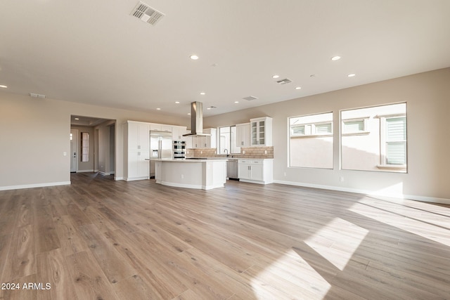 unfurnished living room with light hardwood / wood-style flooring and sink