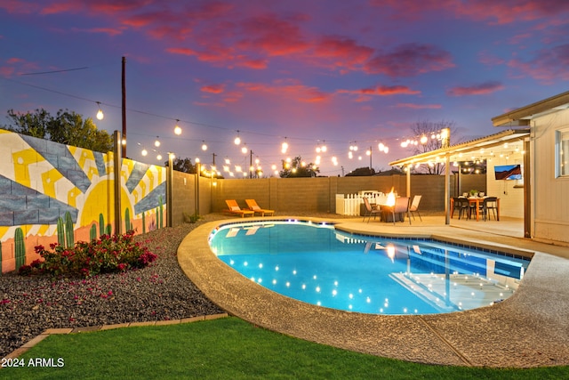 pool at dusk featuring a patio area