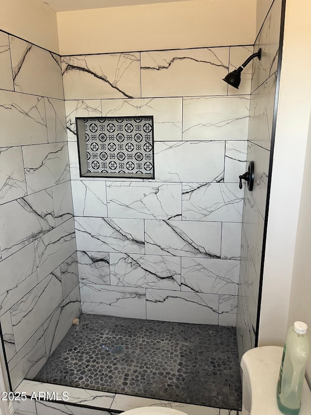 bathroom featuring toilet and tiled shower