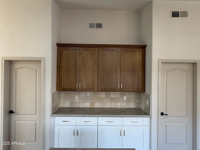 10410 W Daley Ln, Peoria, AZ 85383 - kitchen with visible vents, dark countertops, and decorative backsplash