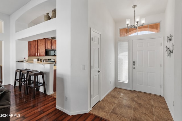 entrance foyer featuring dark wood-type flooring and a chandelier