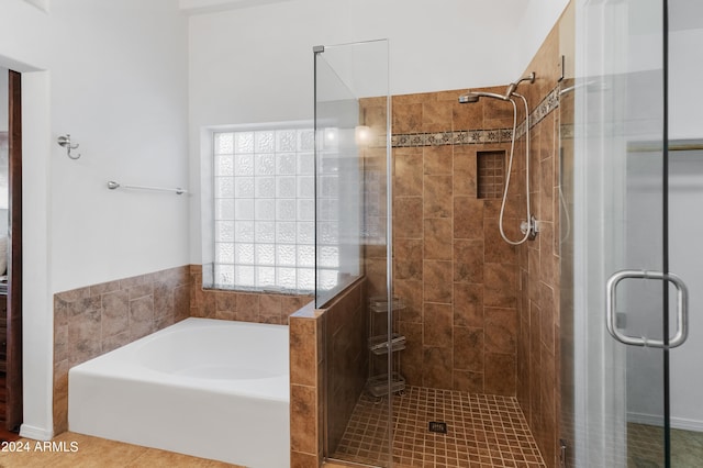 bathroom with independent shower and bath and tile patterned flooring