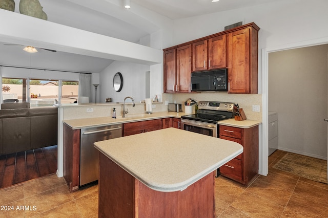 kitchen with sink, vaulted ceiling, stainless steel appliances, and a center island