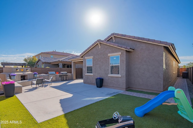 rear view of house featuring a patio and a playground