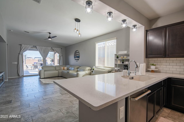 kitchen featuring decorative light fixtures, tasteful backsplash, sink, and kitchen peninsula