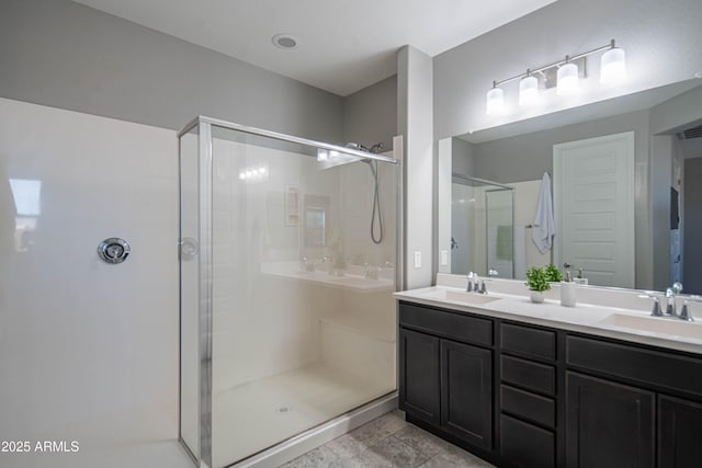 bathroom featuring a shower with door and vanity