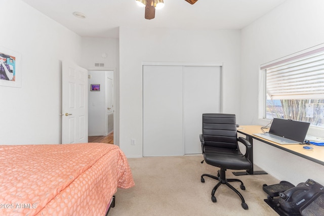 carpeted bedroom featuring ceiling fan and a closet