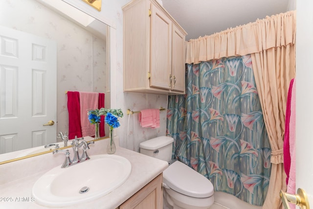 bathroom featuring toilet, vanity, and curtained shower