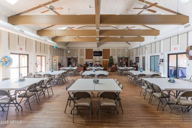 dining room featuring high vaulted ceiling, hardwood / wood-style floors, and beamed ceiling