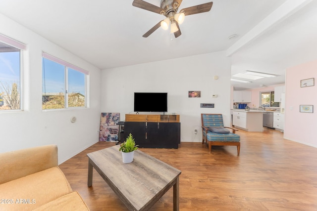 living room featuring light hardwood / wood-style floors, sink, ceiling fan, and vaulted ceiling